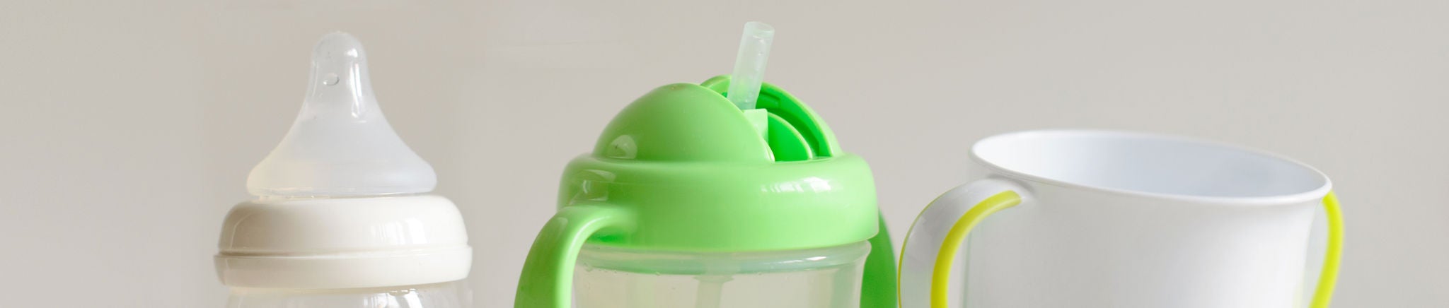 From left to right: a baby bottle, sippy cup and toddler cup.