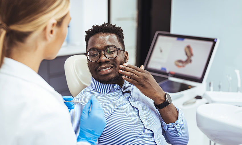 african american man concerned about mouth at dentist