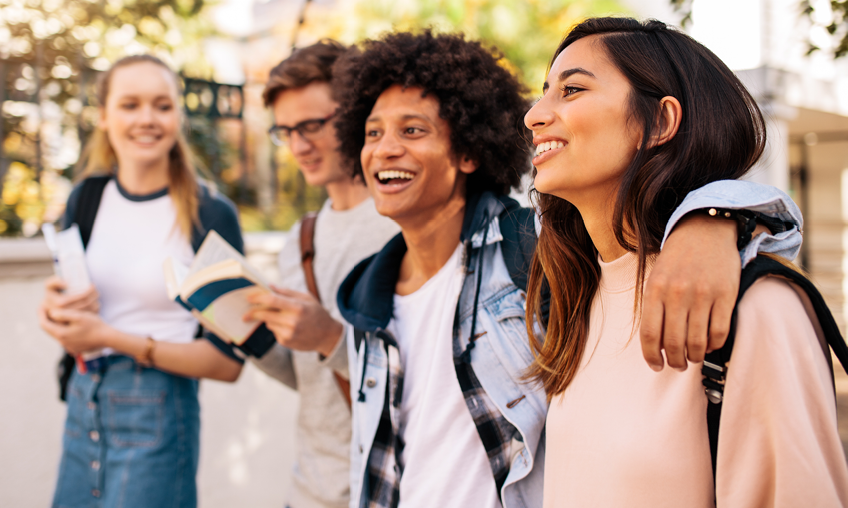 a group of four diverse teens walking down the street